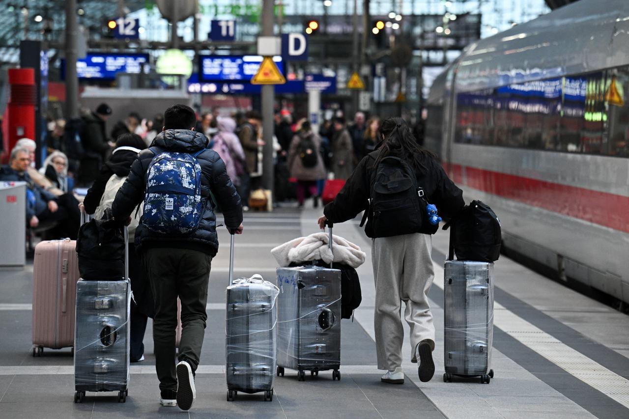 People make their way with their luggage through the main train station, as the annual festive Christmas holidays near in Berlin