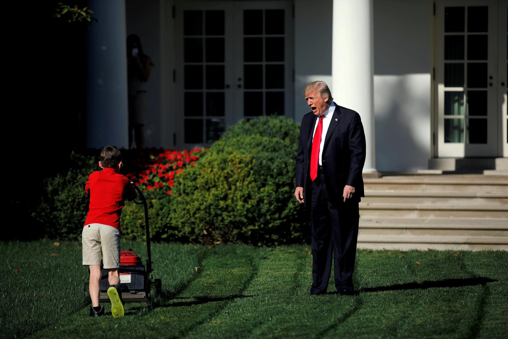 Američki predsjednik Donald Trump pozdravlja 11-godišnjeg Franka Giaccia dok kosi travu ispred Bijele kuće u Washingtonu. 
