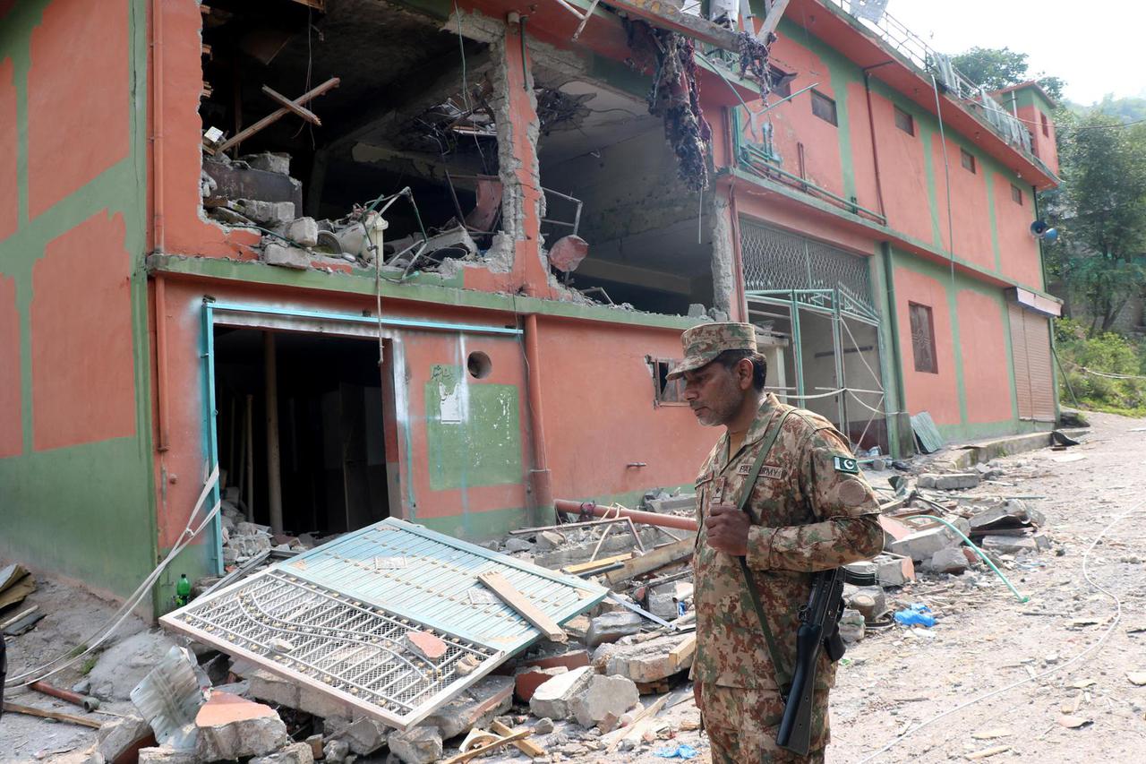 A Pakistan Army soldier stands in front of damaged Bilal Mosque after it was hit by an Indian strike in Muzaffarabad