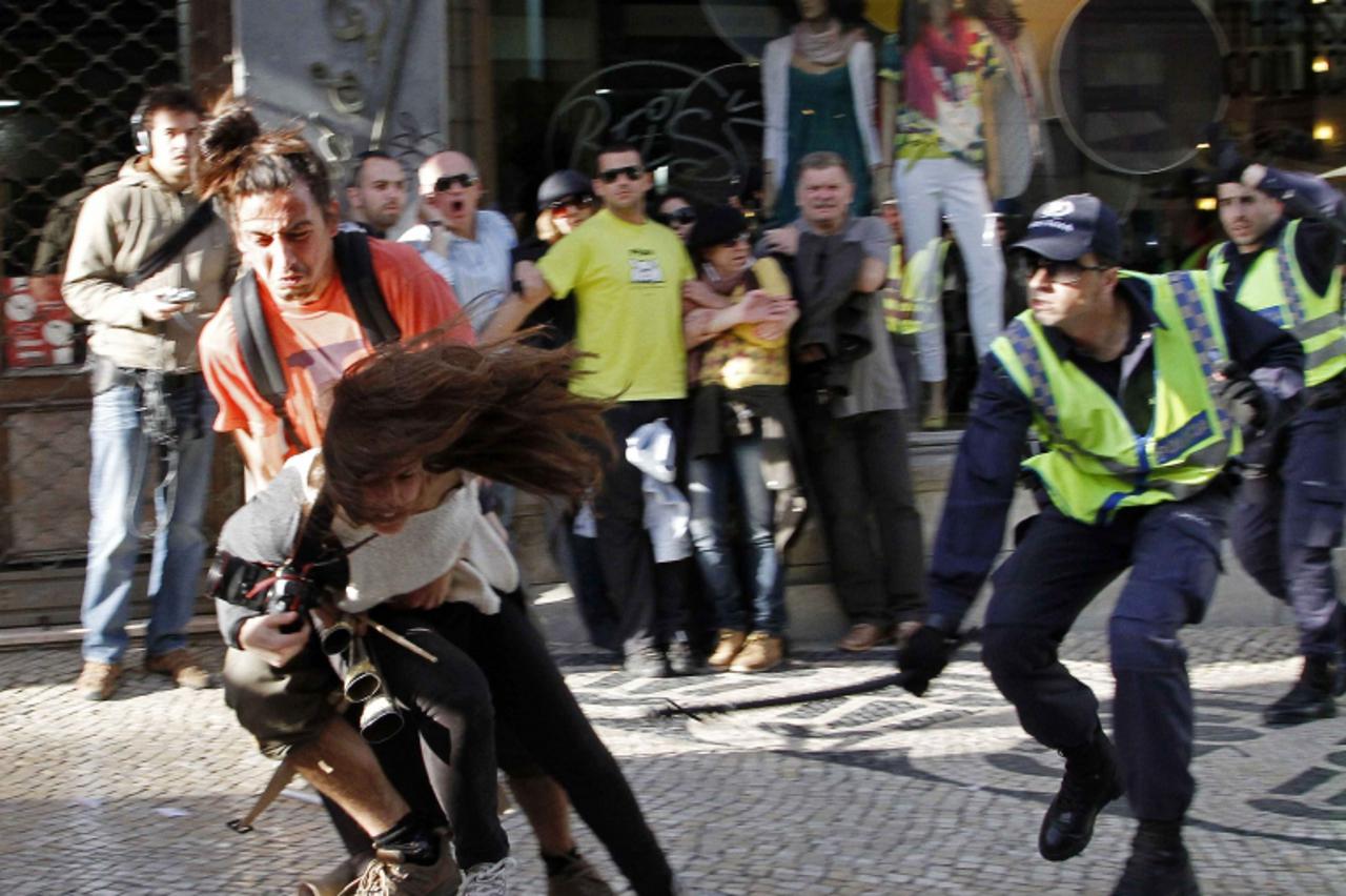 'RNPS IMAGES OF THE YEAR 2012 - A policeman strikes AFP photojournalist Patricia Melo during the Portuguese general strike in Lisbon March 22, 2012. Portugal faces a general strike by workers angered 