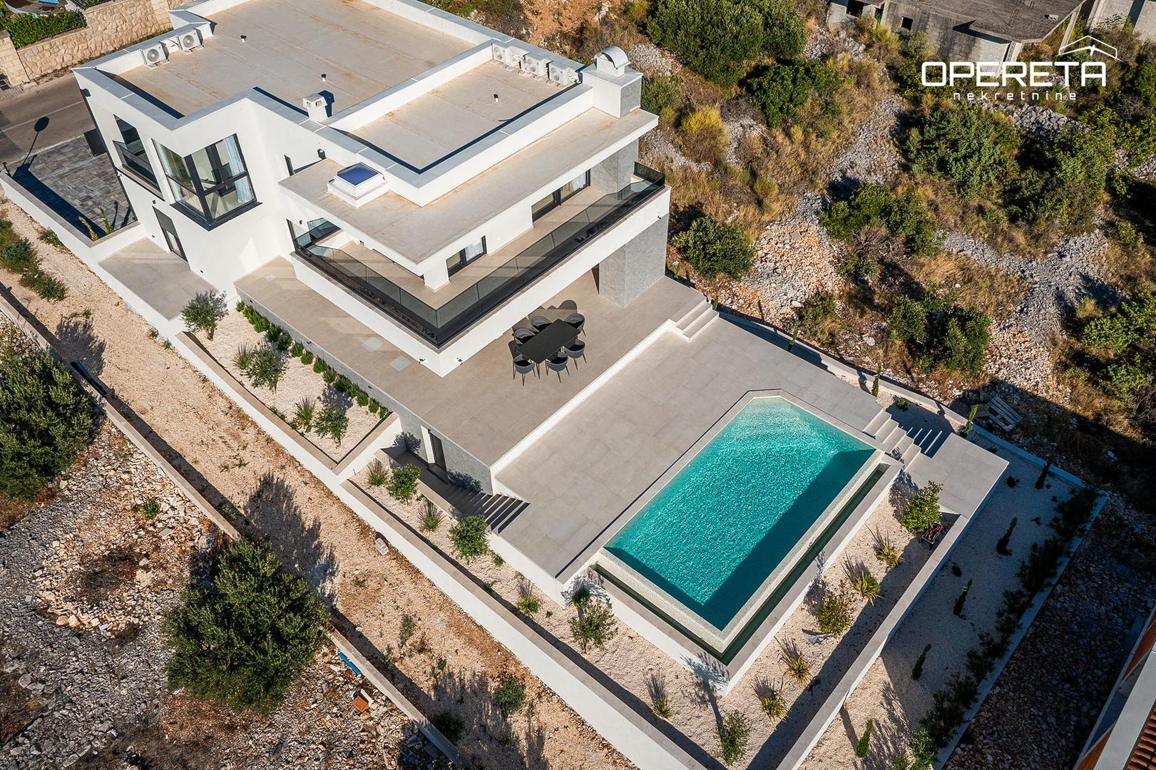 Na parceli od 600 m² je vila 225 m² stambene površine, na dvije etaže. "Prizemlje nudi skladan spoj funkcionalnosti i udobnosti: moderna kuhinja u otvorenom konceptu s blagovaonicom i dnevnim boravkom koji se otvaraju prema velikoj terasi, dodatna prostorija uređena kao ljetna kuhinja, spavaća soba, kupaonica te praktične prostorije poput vešeraja i spremišta. Na katu vas očekuju tri luksuzne spavaće sobe, svaka s vlastitom kupaonicom, garderobom i privatnom terasom – savršeno za jutarnju kavu s pogledom i potpuni osjećaj privatnosti. Podno grijanje i hlađenje u cijeloj kući", navodi se. 

