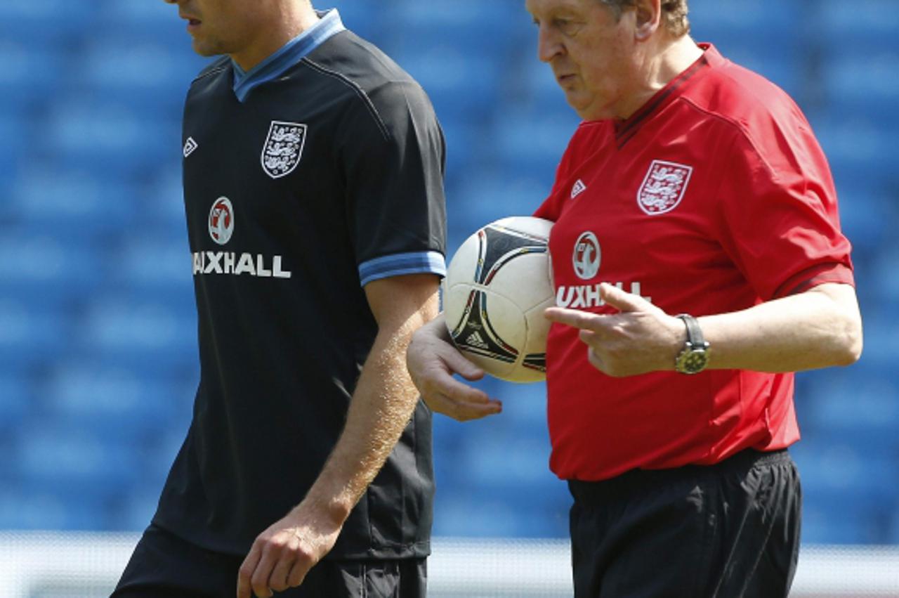 'England soccer coach Roy Hodgson (R) walks with team captain Steven Gerrard during a training session at Manchester City\'s Etihad Stadium in Manchester, northern England May 24, 2012. REUTERS/Phil N
