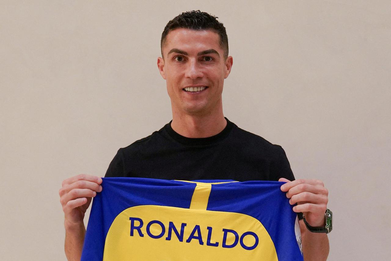 Portuguese soccer player Cristiano Ronaldo holds a shirt of the Saudi club Al-Nassr after signing the contract, in Madrid