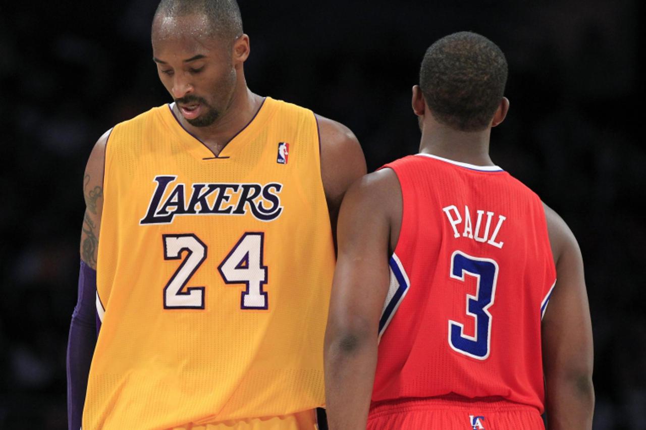 'Los Angeles Lakers' Kobe Bryant (L) brushes past Los Angeles Clippers' Chris Paul during their NBA preseason basketball game in Los Angeles, California December 19, 2011. REUTERS/Lucy Nicholson (UN
