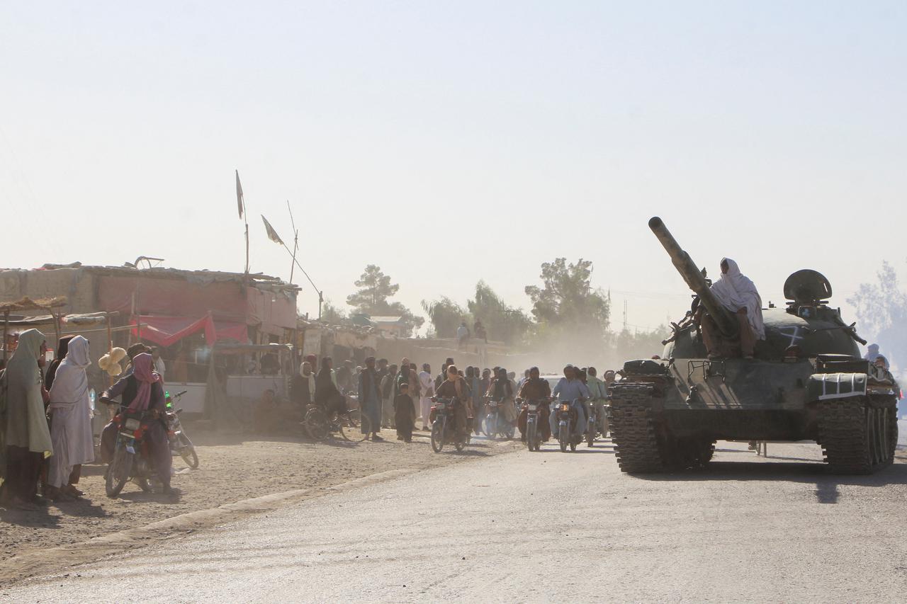 An Afghan Taliban fighter sits on a tank near the Afghanistan-Pakistan border in Spin Boldak, Kandahar Province, following exchanges of fire between Pakistani and Afghan forces