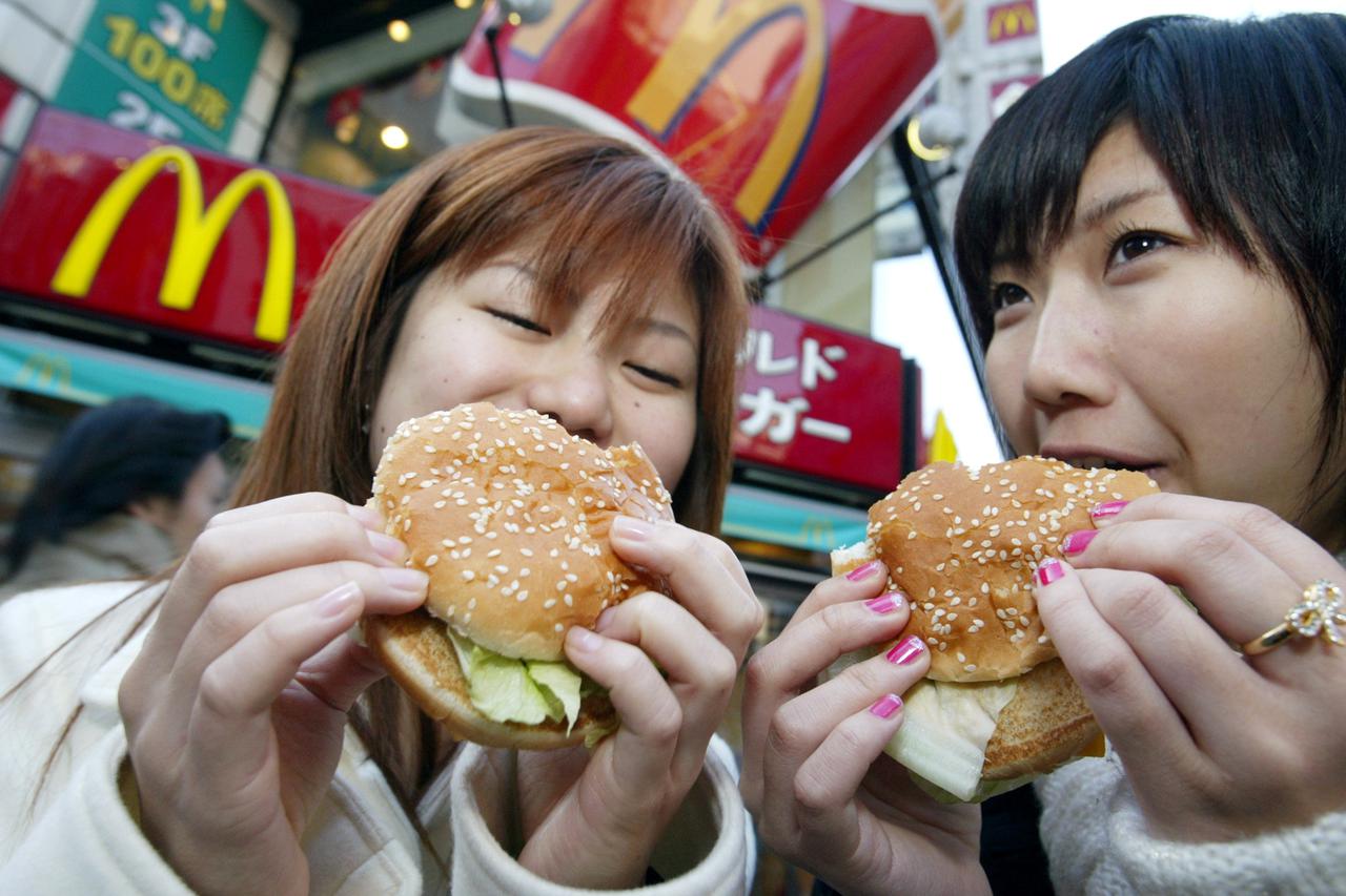 Japanese teenagers enjoy McDonald's Big Macs in Tokyo December 24, 2003.   REUTERS/Eriko Sugita/File Photo