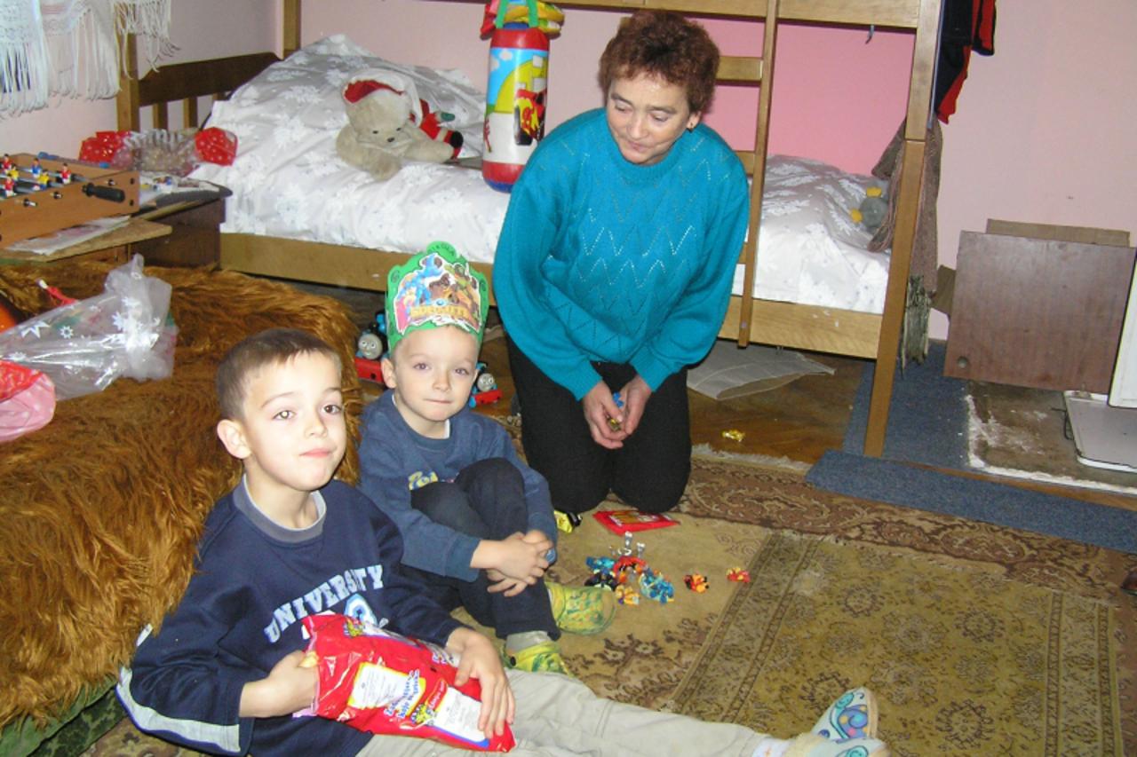 \'zagorje - 10. 12. 2010.,Budinscina, Hrvatska - s lijeva na desno - 7-godisnji Dario, 6-godisnji Nikola i baka Stefa uzivaju u igri i slatkisima\'