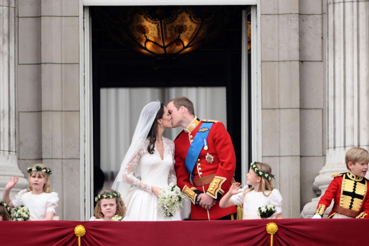 'Britain\'s Prince William and his wife Kate, Duchess of Cambridge kiss on the balcony in Buckingham Palace, after the wedding service, on April 29, 2011, in London.    AFP PHOTO / LEON NEAL'