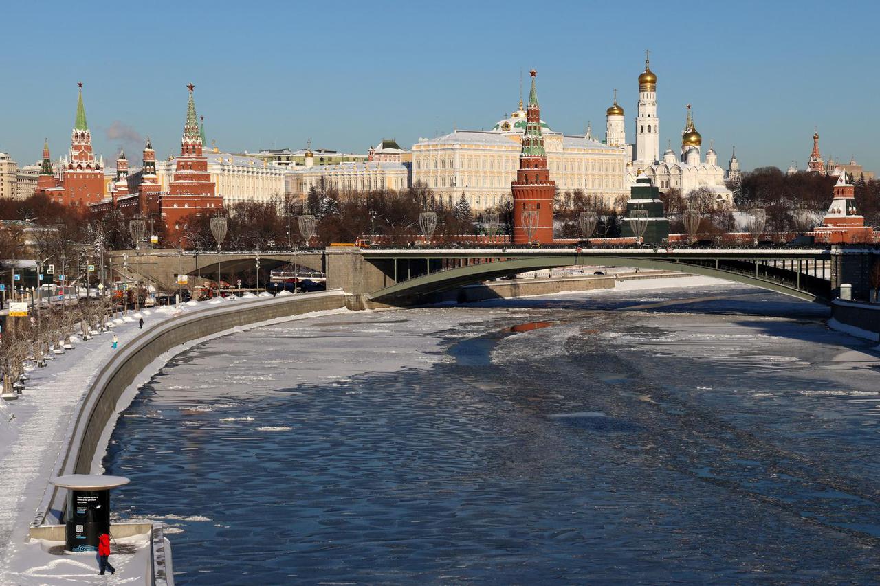 A pedestrian forms a heart shape with footprints on a snow‑covered embankment in Moscow