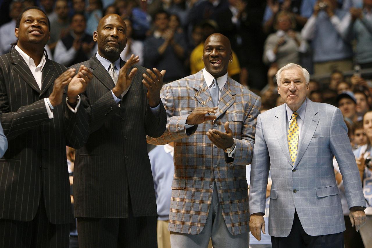 Former University of North Carolina players Sam Perkins, James Worthy, and Michael Jordan, along with former North Carolina head basketball coach Dean Smith (L-R) watch a presentation honoring the 1957 and 1982 national championship teams at halftime of t