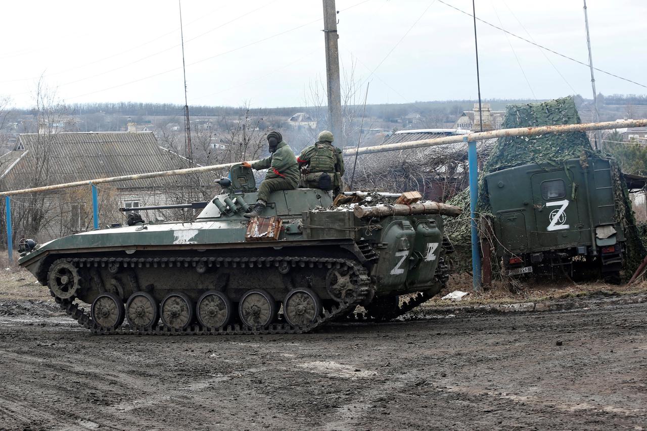 Service members of pro-Russian troops in uniforms without insignia drive an armoured vehicle in the Donetsk region