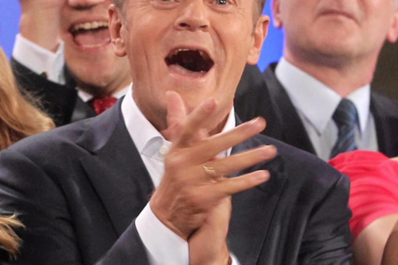 'Poland\'s Prime Minister Donald Tusk (C), claps his hands after the election results announcement in Warsaw October 9, 2011. Polish Prime Minister Donald Tusk claimed victory in Sunday\'s election af