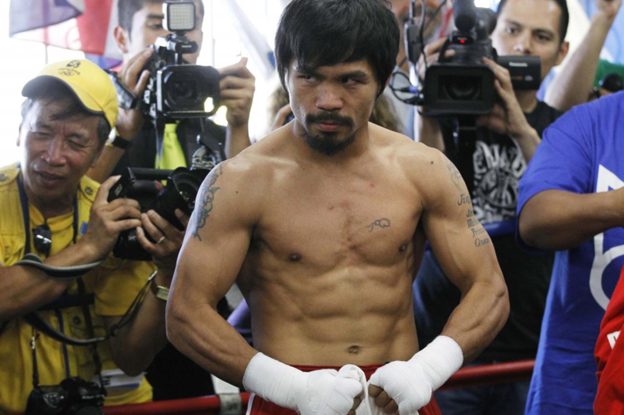 'Congressman and boxer Manny Pacquiao of the Philippines flexes his muscles for the camera during a media workout at Wild Card Boxing Club in Los Angeles April 20, 2011 as he prepares to defend his Wo