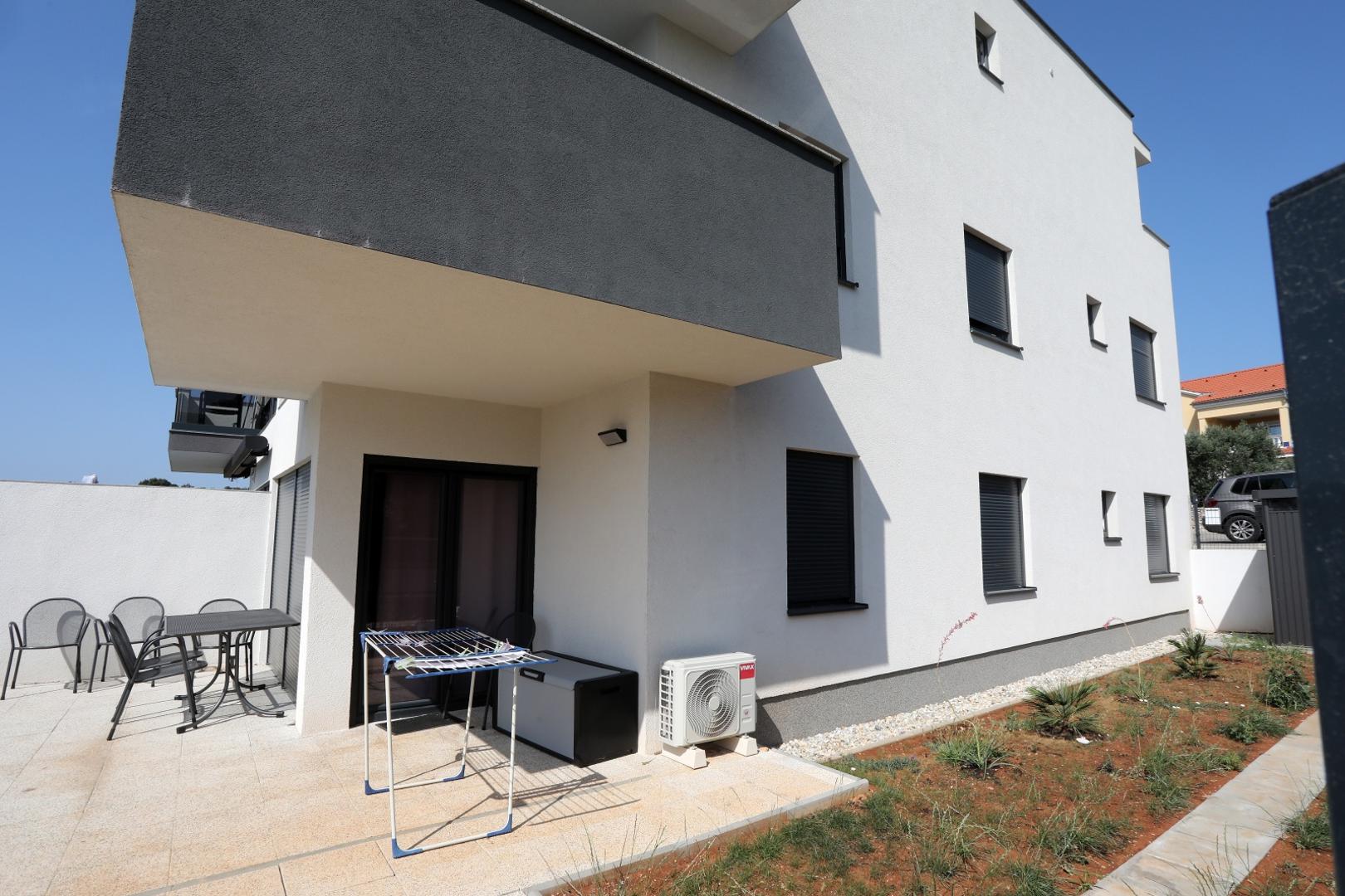 28.07.2021., Krk - Zgrada u ulici Mali Kartec u kojoj je suprug ubio suprugu. Stan u suterenu, ploicijska traka na vrartima i bijeli Volvo kojem je udubljen krov po kojem je lupao suprug ubojica.Photo: Goran Kovacic/PIXSELL