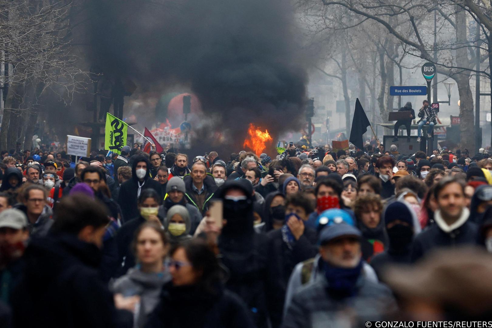 Protesters walk past a fire during a demonstration as part of the tenth day of nationwide strikes and protests against French government's pension reform, in Paris, France, March 28, 2023. REUTERS/Gonzalo Fuentes Photo: GONZALO FUENTES/REUTERS