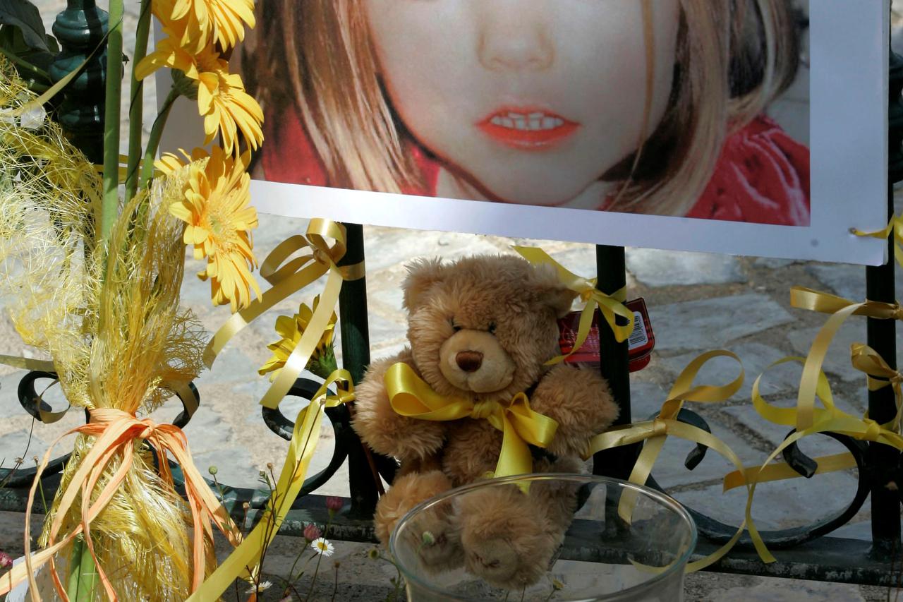 FILE PHOTO: Poster of the missing three-year-old British girl Madeleine McCann is surrounded by flowers and hope-bows in the Portuguese beach resort of Lagos