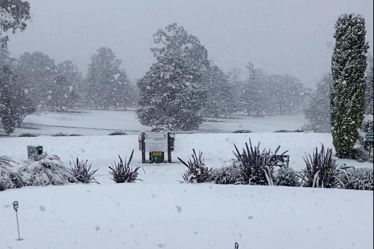 Snow blankets the grass at a Golf Club, in Armidale