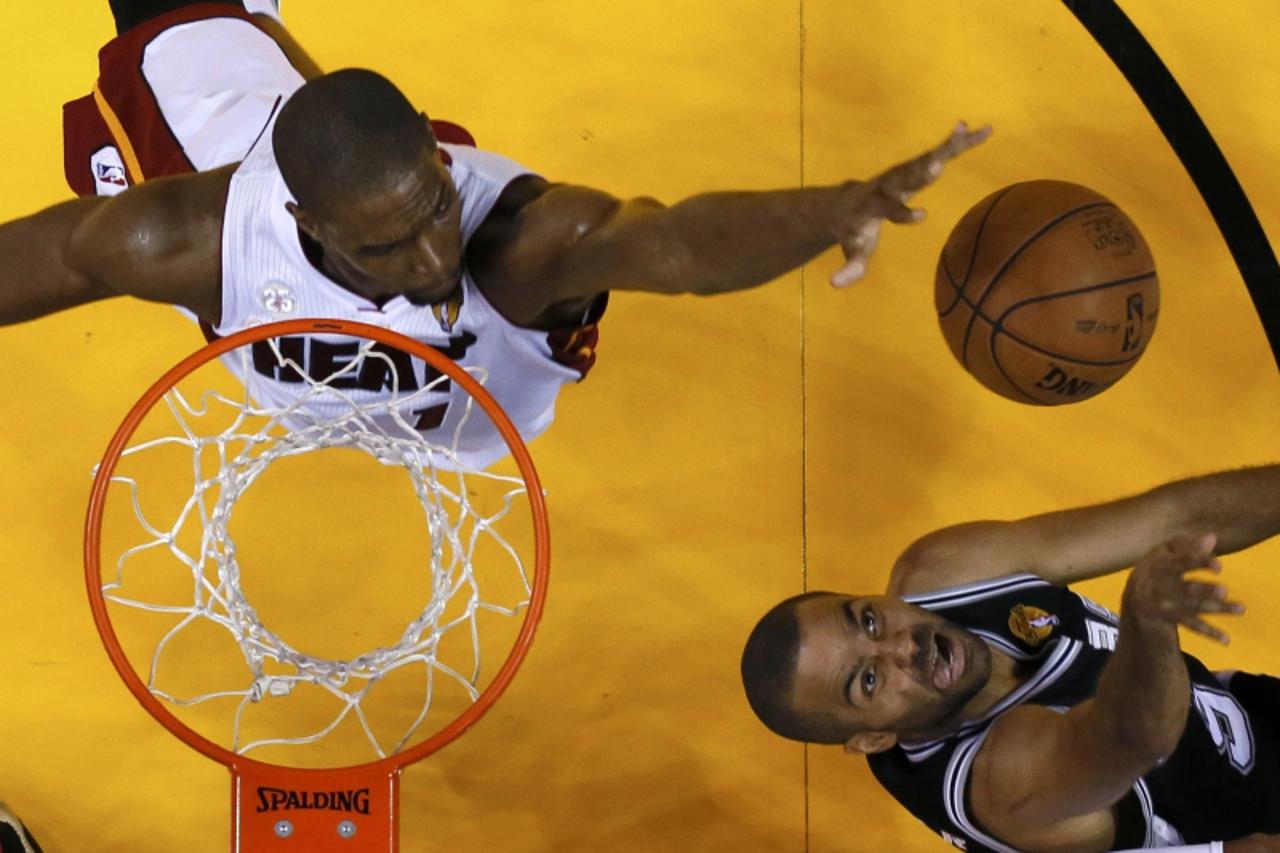 'Miami Heat center Chris Bosh (1) blocks a shot by San Antonio Spurs point guard Tony Parker (9) during Game 7 of their NBA Finals basketball playoff in Miami, Florida June 20, 2013. REUTERS/Mike Ehrm