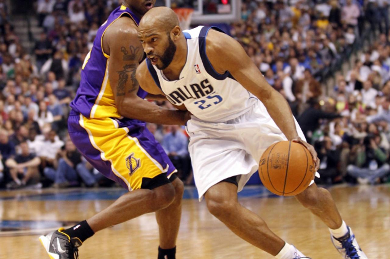'Dallas Mavericks guard Vince Carter (R) drives past Los Angeles Lakers guard Kobe Bryant during the first half of their NBA basketball game in Dallas, Texas February 22, 2012.  REUTERS/Mike Stone (UN