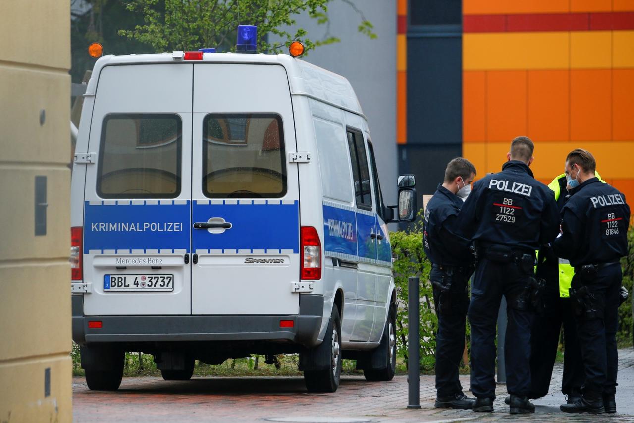Police officers stand near the Oberlin Clinic, where dead and injured people were found, in Potsdam