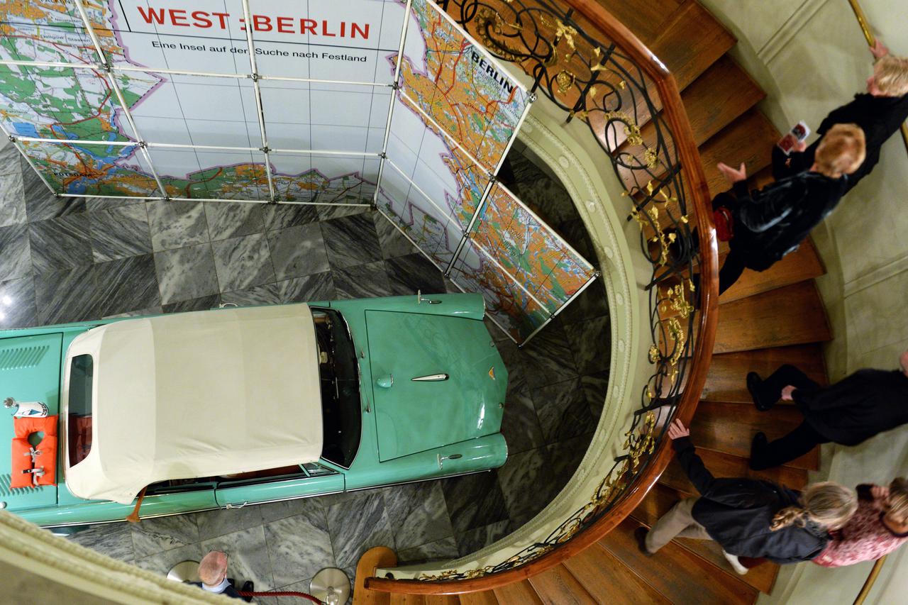 Visitors look at the buoyant convertible 'Amphicar' from the 1960s on the opening day of the exhibition 'WEST:BERLIN - An island in search of mainland' at the Stadtmuseum Berlin in Berlin, Germany, 13 November 2014. The show which features about 500 exhib