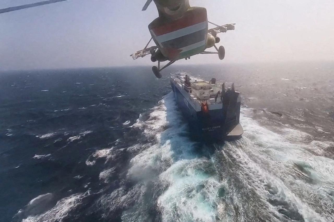 FILE PHOTO: Houthi military helicopter over the Galaxy Leader cargo ship in the Red Sea