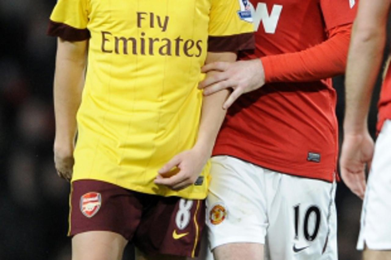 \'Manchester United\'s Wayne Rooney speaks to Arsenal\'s Samir Nasri during their FA Cup quarter-final soccer match at Old Trafford in Manchester, northern England March 12, 2011. REUTERS/Russell Chey
