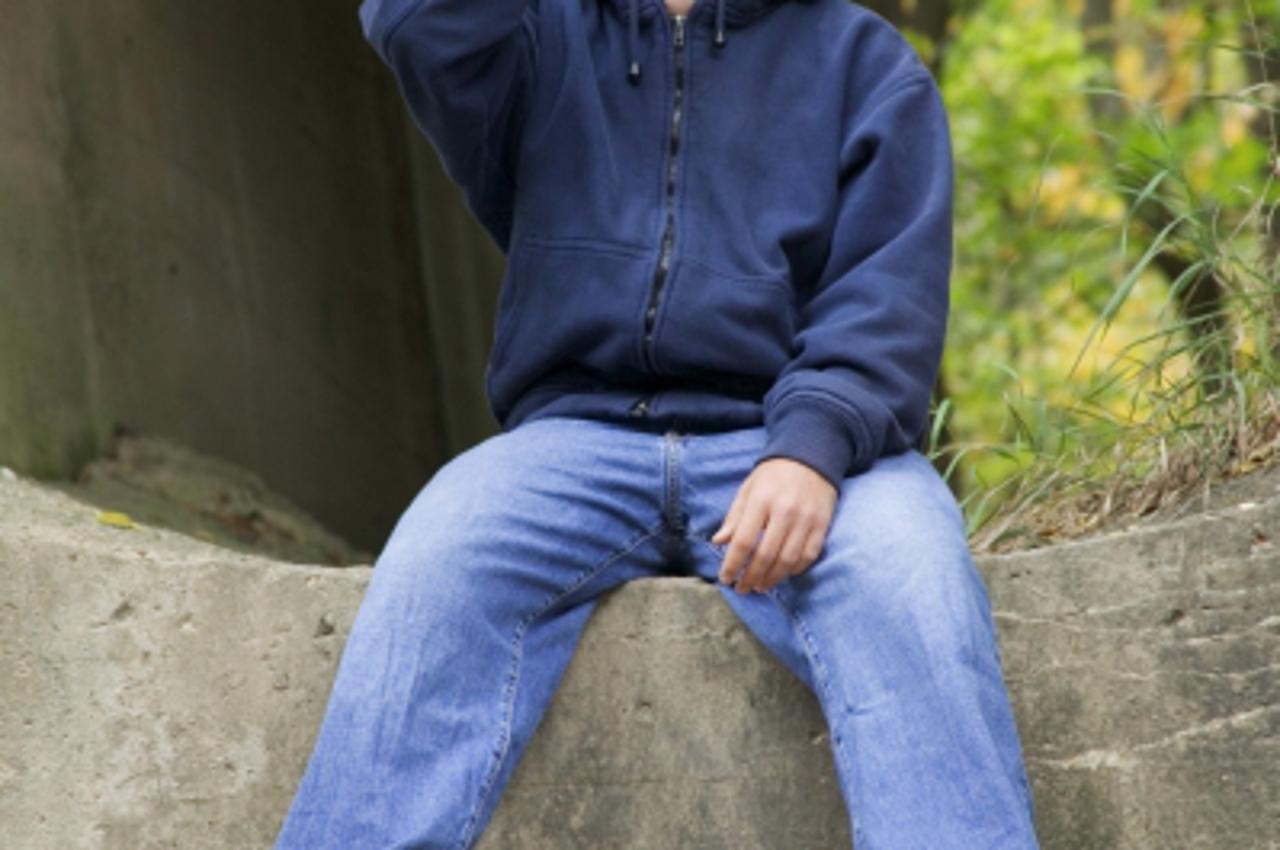 'Homeless teenage boy drinking a bottle of beer'