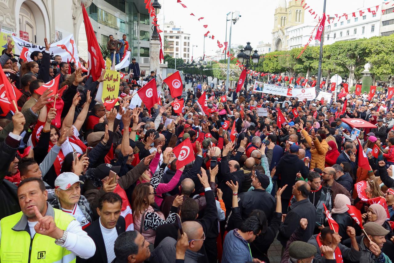 Supporters of Tunisia's President Kais Saied carry flags and banners during a rally in Tunis