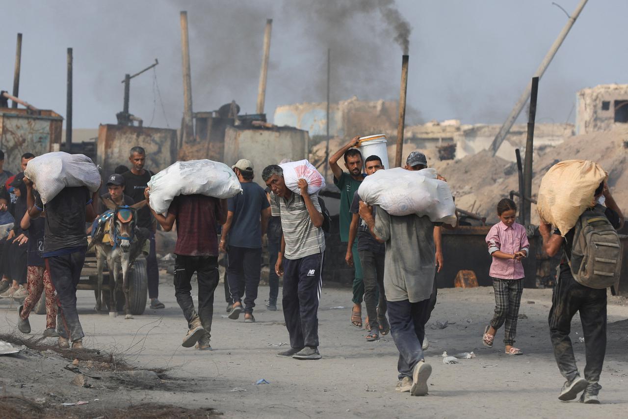 Palestinians seek aid supplies from trucks that entered Gaza through Israel, in Beit Lahia, in the northern Gaza Strip