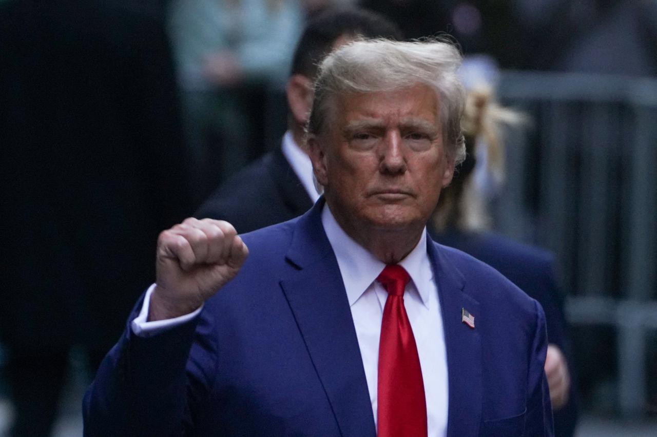 FILE PHOTO: Former U.S. President Donald Trump gestures to his supporters outside a Trump property in New York City