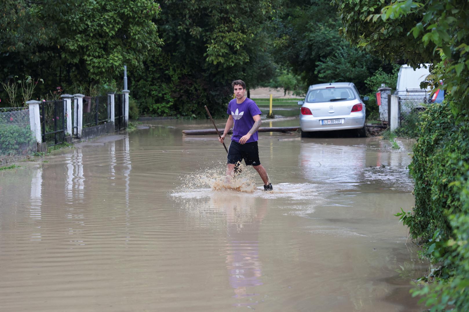 A man wades in water during floods in Domzale, Slovenia August 4, 2023. REUTERS/Borut Zivulovic Photo: BORUT ZIVULOVIC/REUTERS