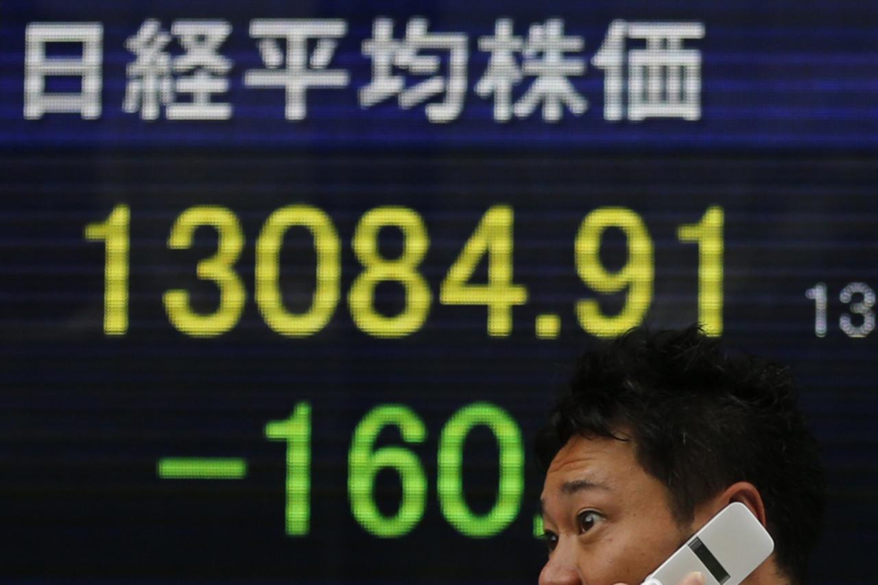 'A man walks past a stock quotation board displaying Japan's Nikkei share average outside a brokerage in Tokyo June 20, 2013. Japan's Nikkei share average fell on Thursday as weak China data further
