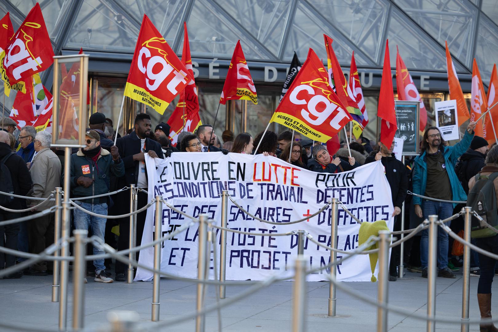 Museum staff hold banners outside the Pyramid of the Louvre Museum as workers voted to go on strike against increasingly deteriorating working conditions and the declining visitor experience at the world famous museum, in Paris on December 15, 2025. Photo by Raphael Lafargue/ABACAPRESS.COM Photo: Lafargue Raphael/ABACA/ABACA