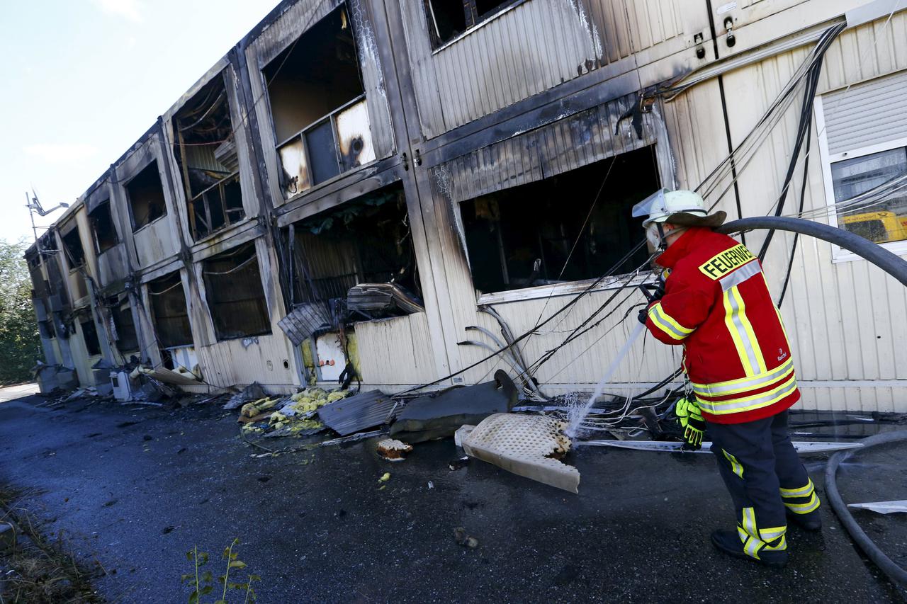 A German firefighter examines a building used as an asylum shelter after a fire broke out there, in Rottenburg, Germany, in this file picture taken September 7, 2015. German federal police have counted 26 arson attacks on refugee shelters in the first nin