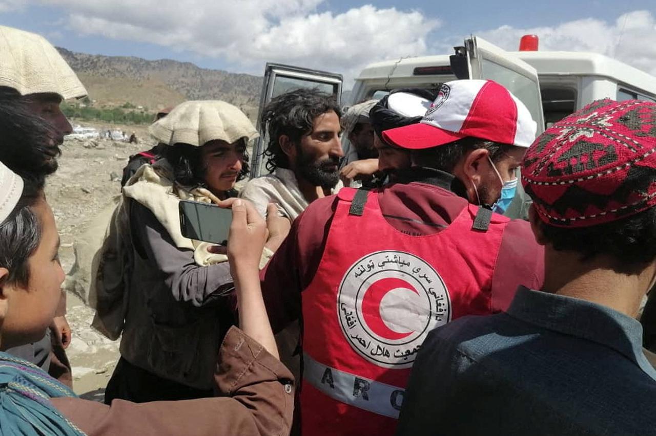 Afghan Red Crescent medics and volunteers transport earthquake victims to hospitals, in Spera district