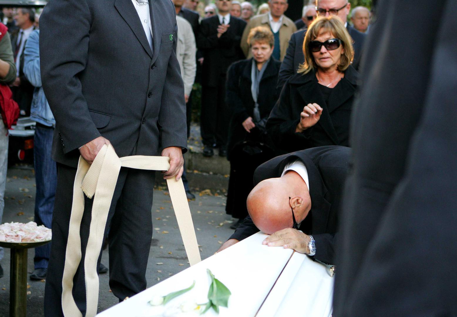 10.10.2008. Zagreb, Hrvatska. Na groblju Mirogoj pokopana je Ivana Hodak, kcer odvjetnika Zvonimira Hodaka i bivse politicarke Ljerke Mintas Hodak, koja je s dva hica u glavu ubijena ispred ulaza u svoj stan u ulici Pavla Hatza 2. Ivanu su ispratili brojni politicari, prijatelji i osobe s estrade. Pripadnica 'zlatne' hrvatske mladezi bila je u vezi s odvjetnikom Ljubom Pavasovicem Viskovic koji nije mogao suspregnuti suze.Ivanini roditelji Zvonimir Hodak i Ljerka Mintas Hodak oprastaju se od svoje kceri.r"nPhoto Zeljko Lukunic/PIXSELL