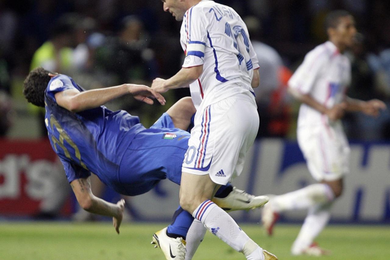 \'Italy\'s Marco Materazzi falls on the pitch after being head-butted by France\'s Zinedine Zidane (R) during their World Cup 2006 final soccer match in Berlin July 9, 2006. FIFA RESTRICTION - NO MOBI