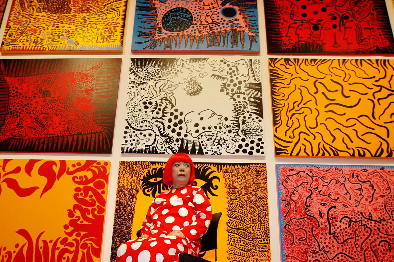 FILE PHOTO: Artist Yayoi Kusama poses for a photograph with her artwork "Love arrives at the Earth Carrying with it a Tale of the Cosmos" at the Tate Modern gallery in London