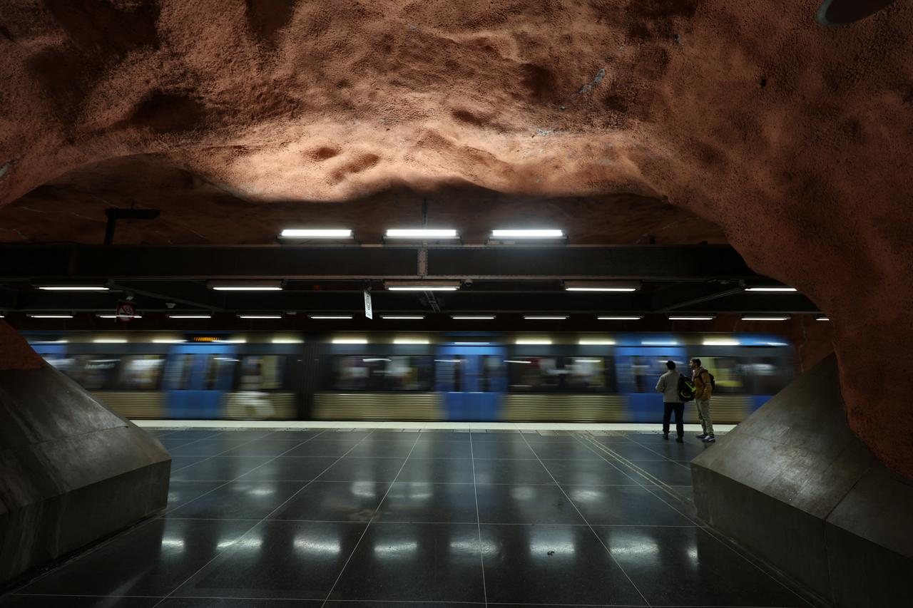 People wait for a train in a subway station in Stockholm