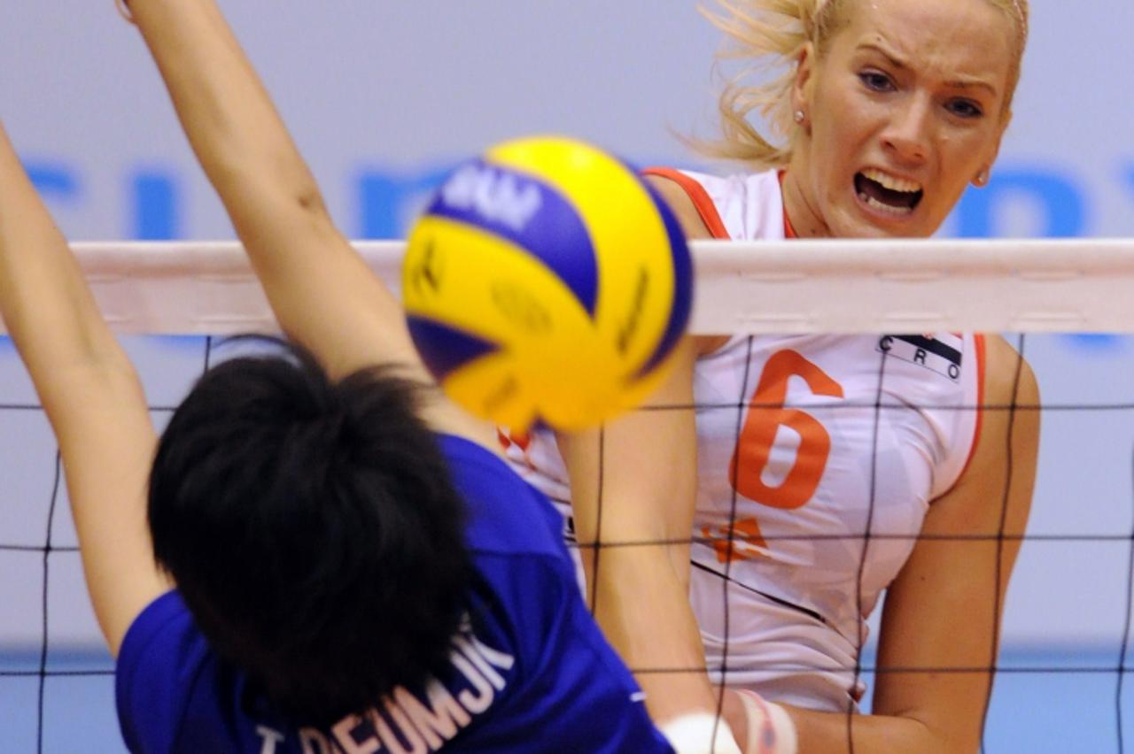 'Sanja Popovic of Croatia (R) spikes the ball past Pleumjit Thinkaow of Thailand (L) during their Pool C preliminary round match at the FIVB 2010 Women\'s Volleyball World Championships in Matsumoto, 