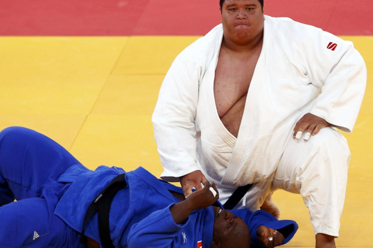 'Guam\'s Ricardo Blas Jr. (R) looks up after winning his men\'s +100kg elimination round of 32 judo match against Guinea\'s Facinet Keita at the London 2012 Olympic Games August 3, 2012.        REUTER