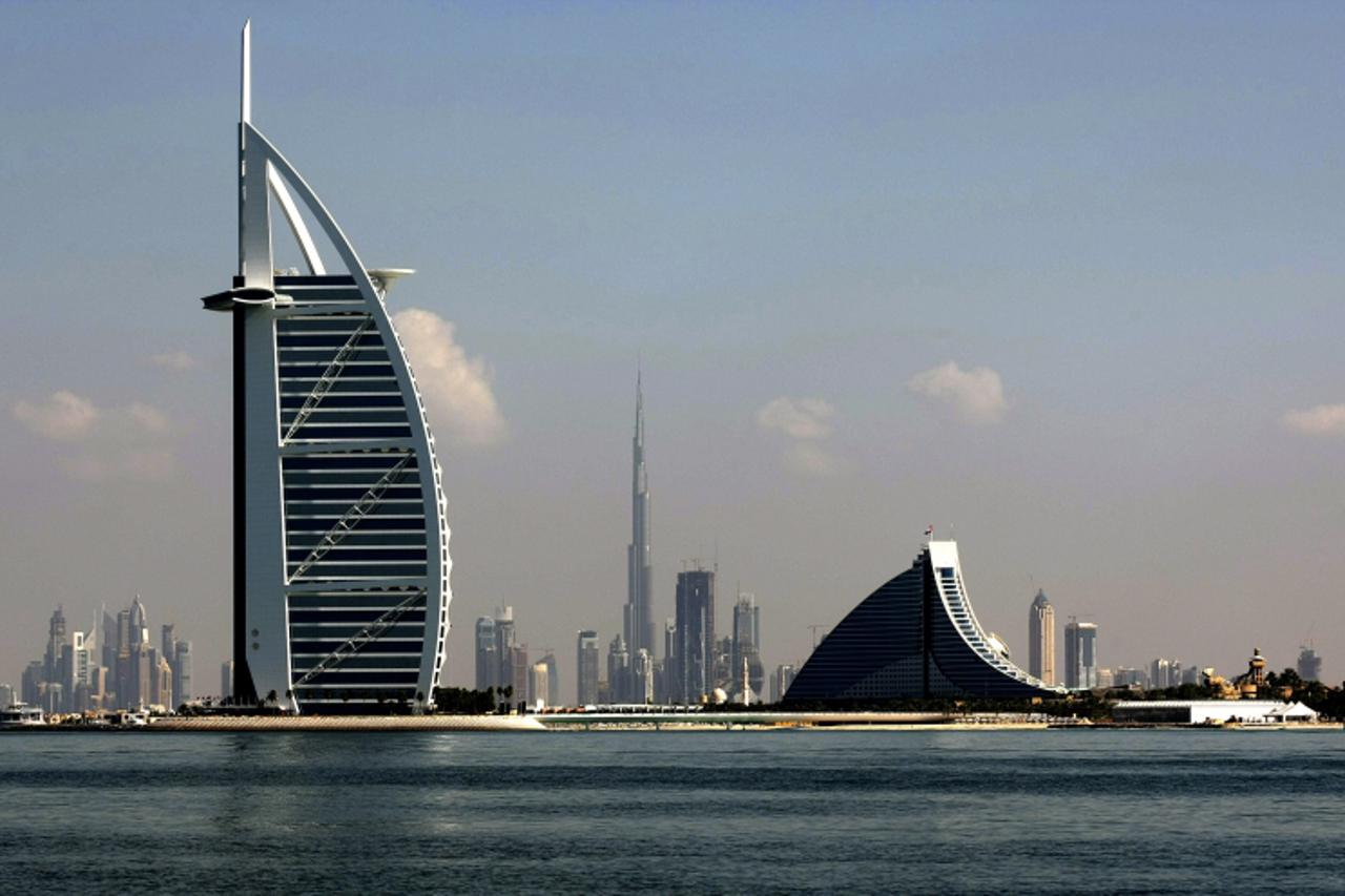 'Dubai\'s three most prominent architectural icons, Burj an-Arab Hotel (L), Jumirah Hotel (R) and Burj Dubai (C), are seen along the coast of Dubai, on December 21, 2009.  Dubai\'s heavily-indebted gr
