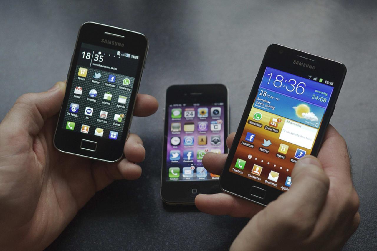 \'A man holds a Samsung S II (R) and Samsung Ace (L) smartphones next to an Apple iPhone 4 in Houten in this file photo illustration taken on August 24, 2011. Samsung Electronics said on October  7, 2
