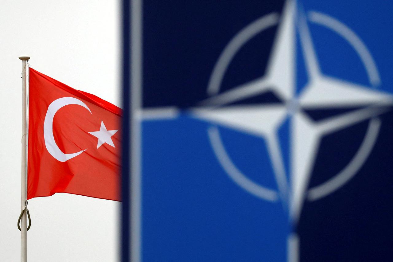 FILE PHOTO: A Turkish flag flies next to NATO logo at the Alliance headquarters in Brussels