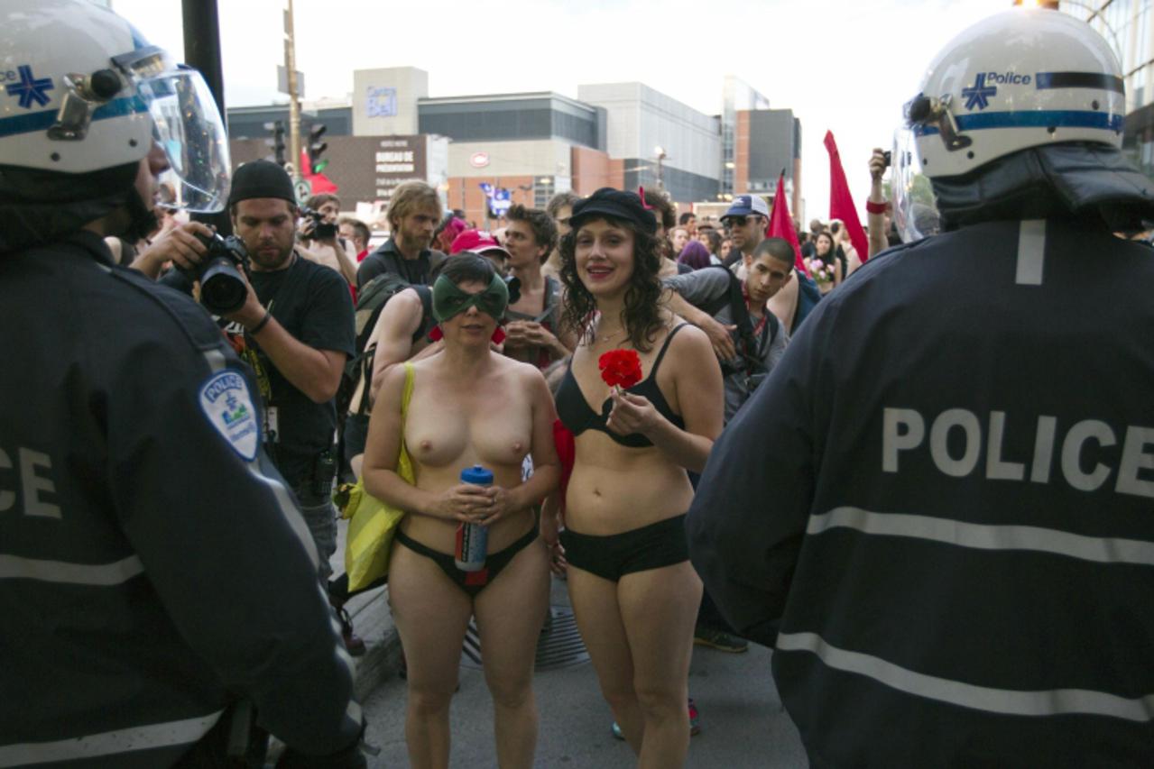 'Naked protesters confront police during a demonstration to disrupt the Canadian F1 Grand Prix gala party in Montreal June 7, 2012.   REUTERS/Christinne Muschi   (CANADA - Tags: CIVIL UNREST CRIME LAW