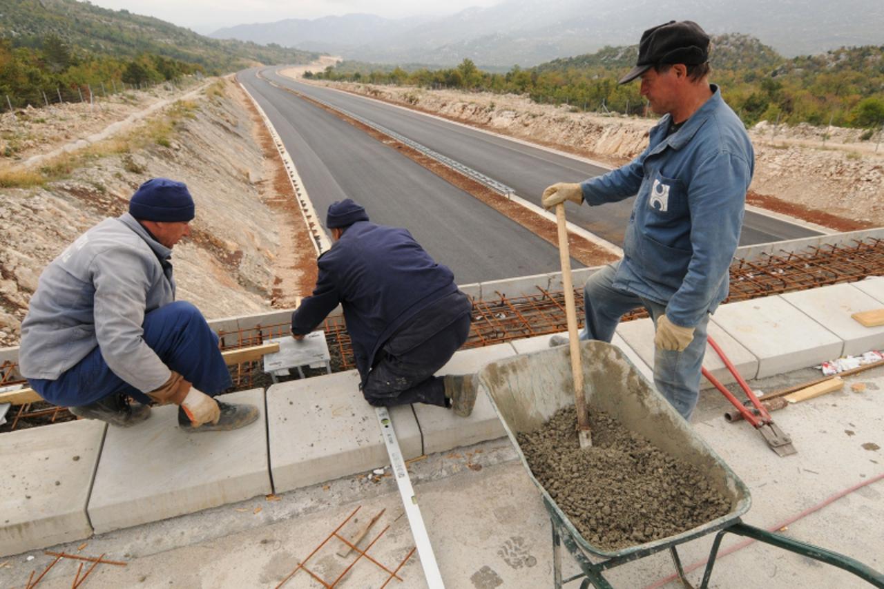 'unu...ravca/zagvozd...17.10.2008...autocesta a1..dalmatina...radovi na dionici zagvozd-ravca...         Photo: Zoran Grizelj/Vecernji list...radnici postavljaju nosace zuastitne ograde na nadvoznjaku