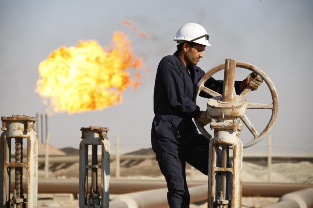 \'A worker adjusts the valve of an oil pipe at West Qurna oilfield in Iraq\'s southern province of Basra November 28, 2010. U.S. oil major ExxonMobil and its partners have awarded a contract to oil se