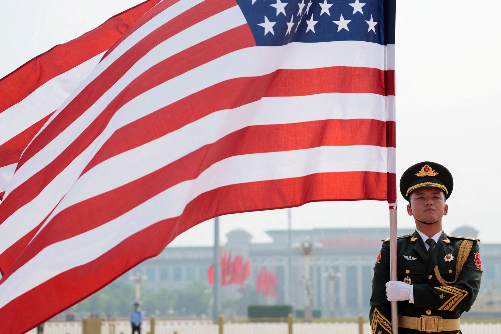 A People's Liberation Army (PLA) member holds up a U.S. flag ahead of the arrival of a welcome ceremony for U.S. President Donald Trump at the Great Hall of the People in Beijing, China, May 14, 2026. REUTERS/Evan Vucci REFILE - QUALITY REPEAT     TPX IMAGES OF THE DAY Photo: Evan Vucci/REUTERS