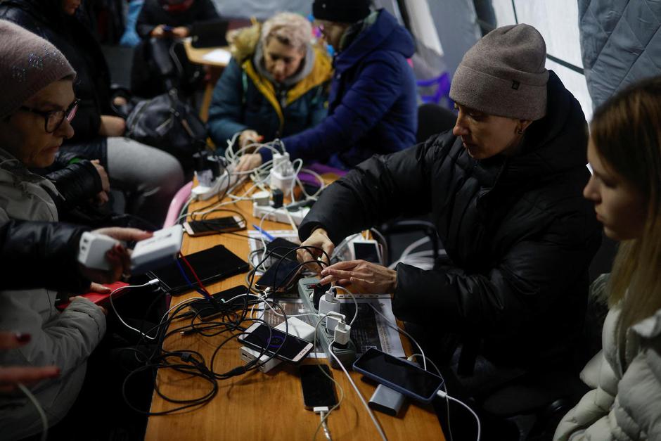 Local residents charge their devices, use internet connection and warm up inside an invincibility centre in Kyiv